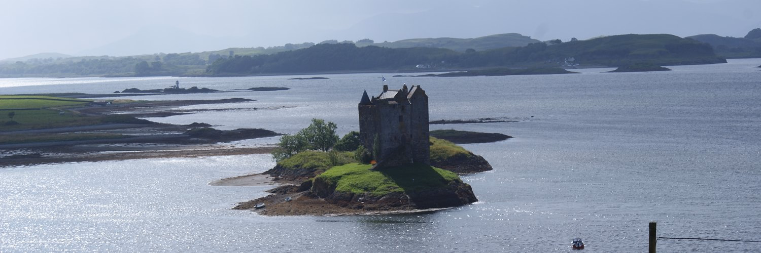 Stalker Castle from the roadside with Lismore in the background
